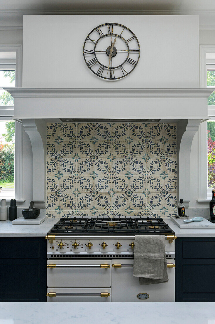 Römische Uhr über dem Ofen mit Kacheln aus gebrannter Erde in einer unter Denkmalschutz stehenden viktorianischen Küche Godalming Surrey UK