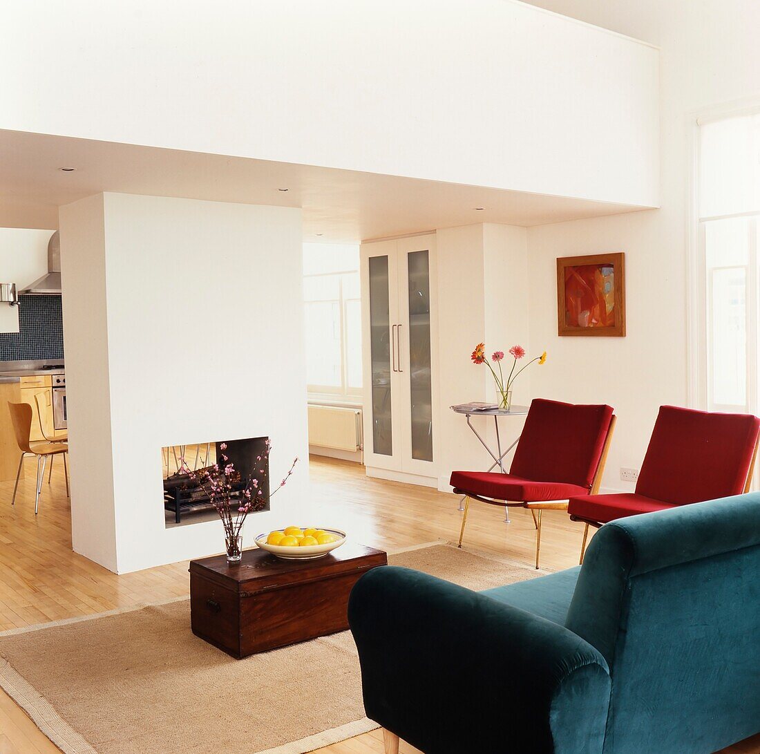 Spacious open plan living and dining areas with central fireplace built into a partition wall 