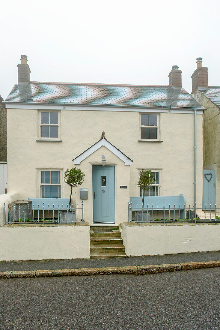 Detached cream beach house with light blue paintwork in Marazion Cornwall UK