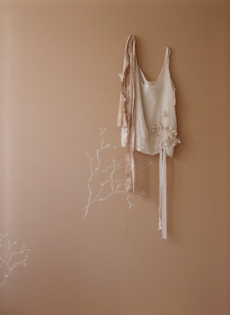 Braunes Papier an der Wand mit Kreidezeichnung und zartem Camisole-Top