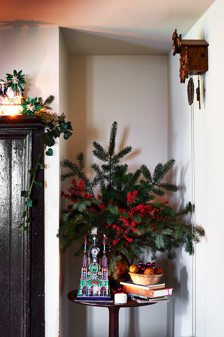 Immergrüne und Stechpalmenbeeren mit altem Weihnachtsschmuck in einem Cottage in Shropshire, England, Vereinigtes Königreich