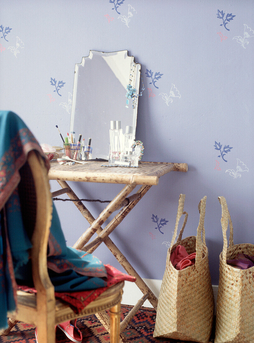 Makeshift boudoir dressing table with purple floral wallpaper