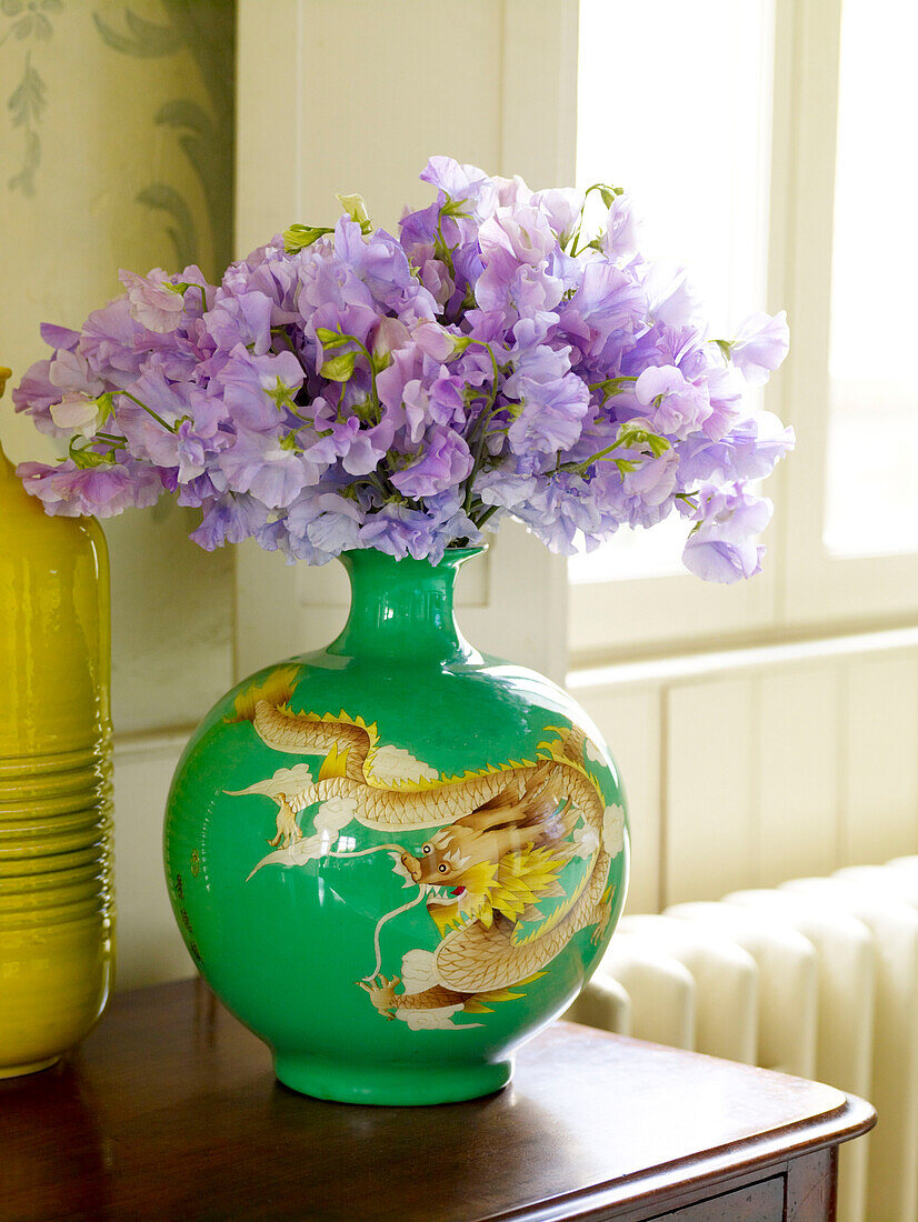 Lila Erbsen (Lathyrus odoratus) in grüner orientalischer Vase