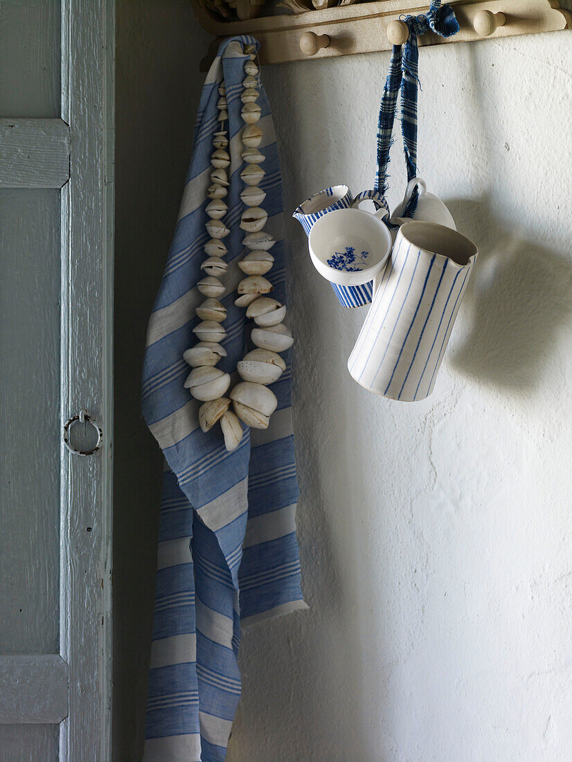 Seashells and dishcloth hang with jugs on hooks Spain