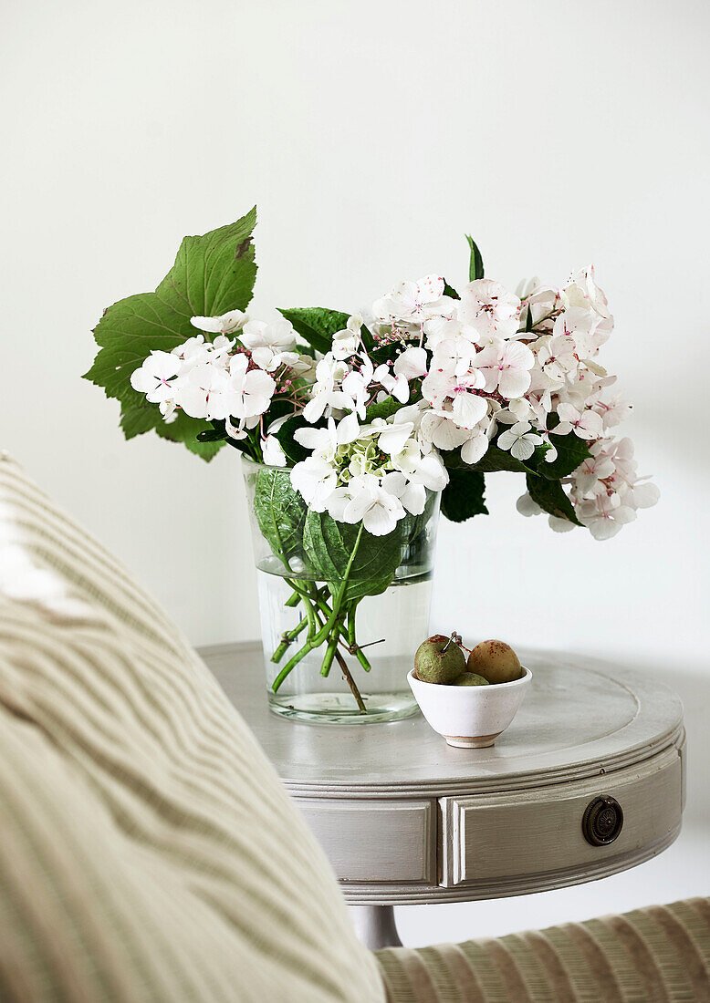 Cut hydrangeas with apples in bowl on side table in Lyme Regis home Dorset UK