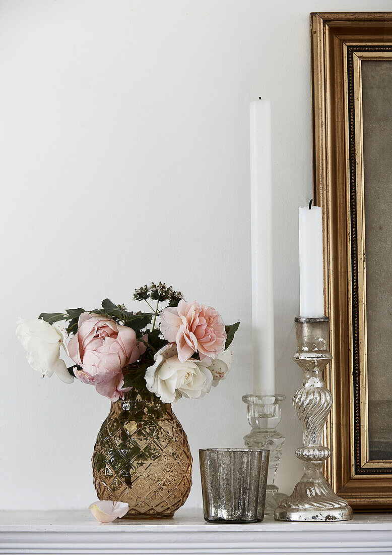 Cut flowers and candlesticks on mantlepiece in Lyme Regis home Dorset UK