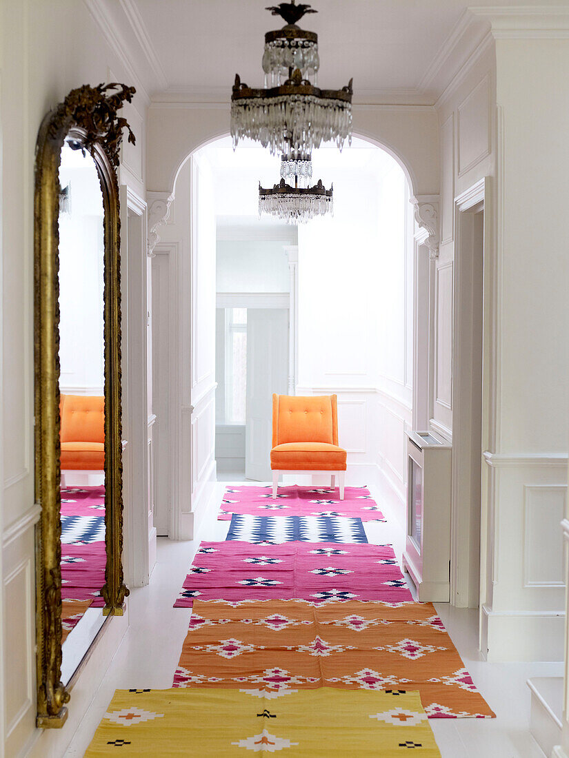 Bright modern hallway with vintage mirror and chandelier