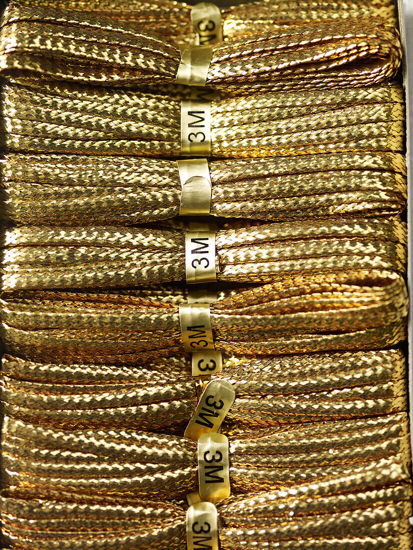 Stacked lengths of three metre gold string