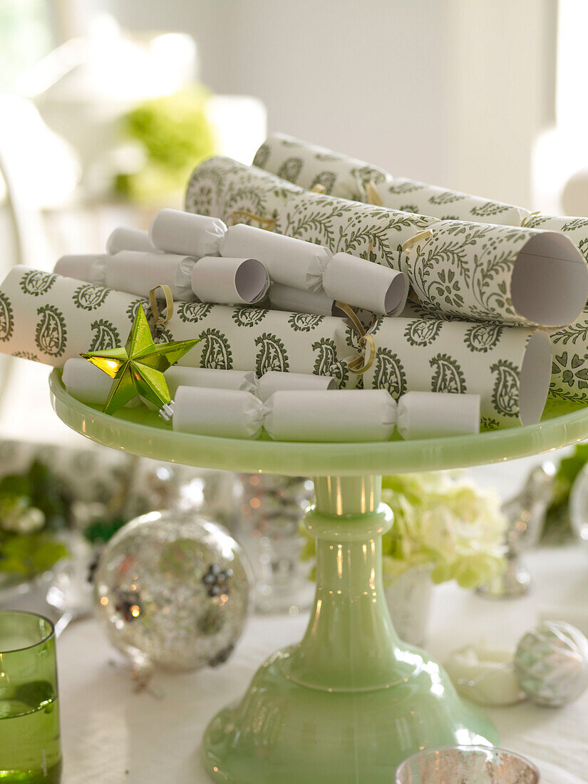 Grüne und weiße Weihnachtskräcker auf Kuchenständer mit Kugeln