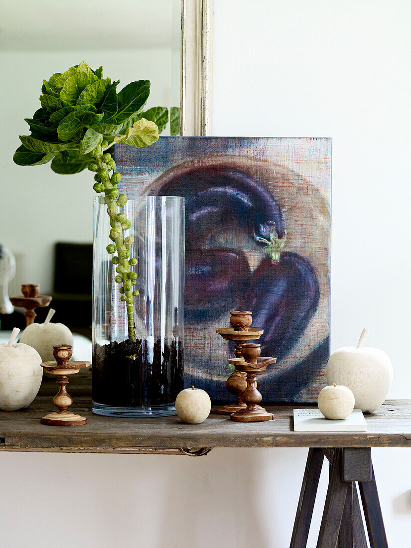 Sprießender Rosenkohl in einer Vase mit Kunstwerk auf einem Gestell