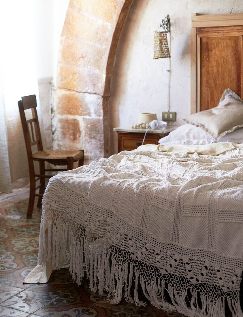 Traditioneller Bezug auf einem ungemachten Bett in einem sizilianischen Haus