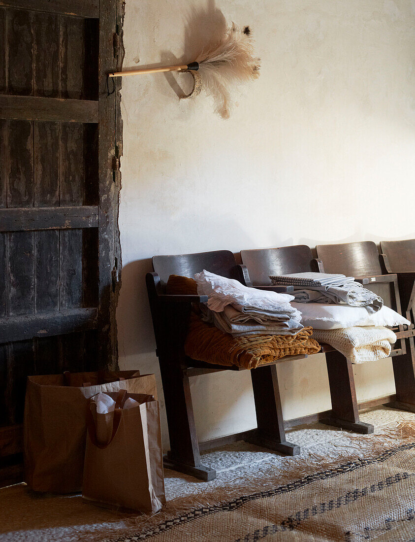 Gefaltete Bettwäsche auf Kinosessel mit Staubwedel in sizilianischem Haus