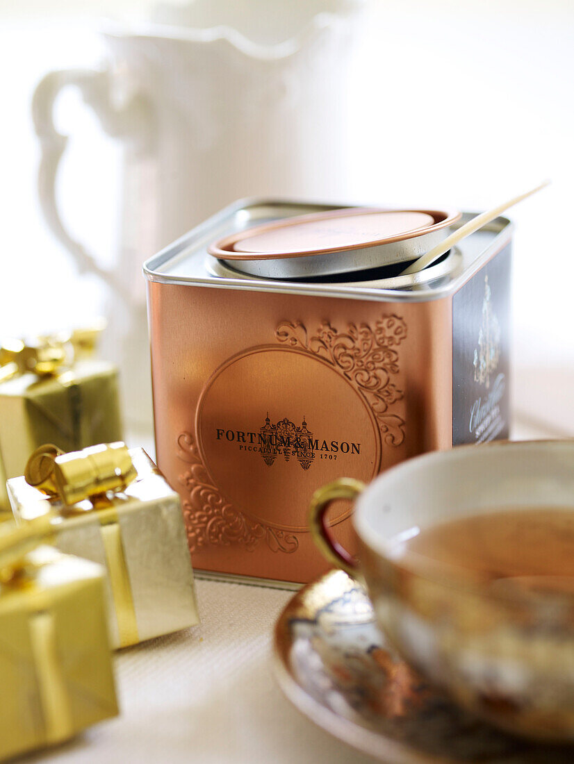 Luxuriöse Teedose mit eingepackten Geschenken und Porzellantasse