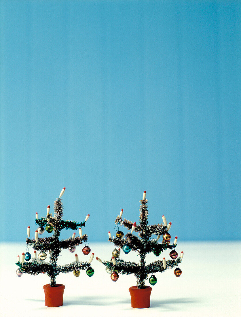 Two tiny artificial Christmas trees
