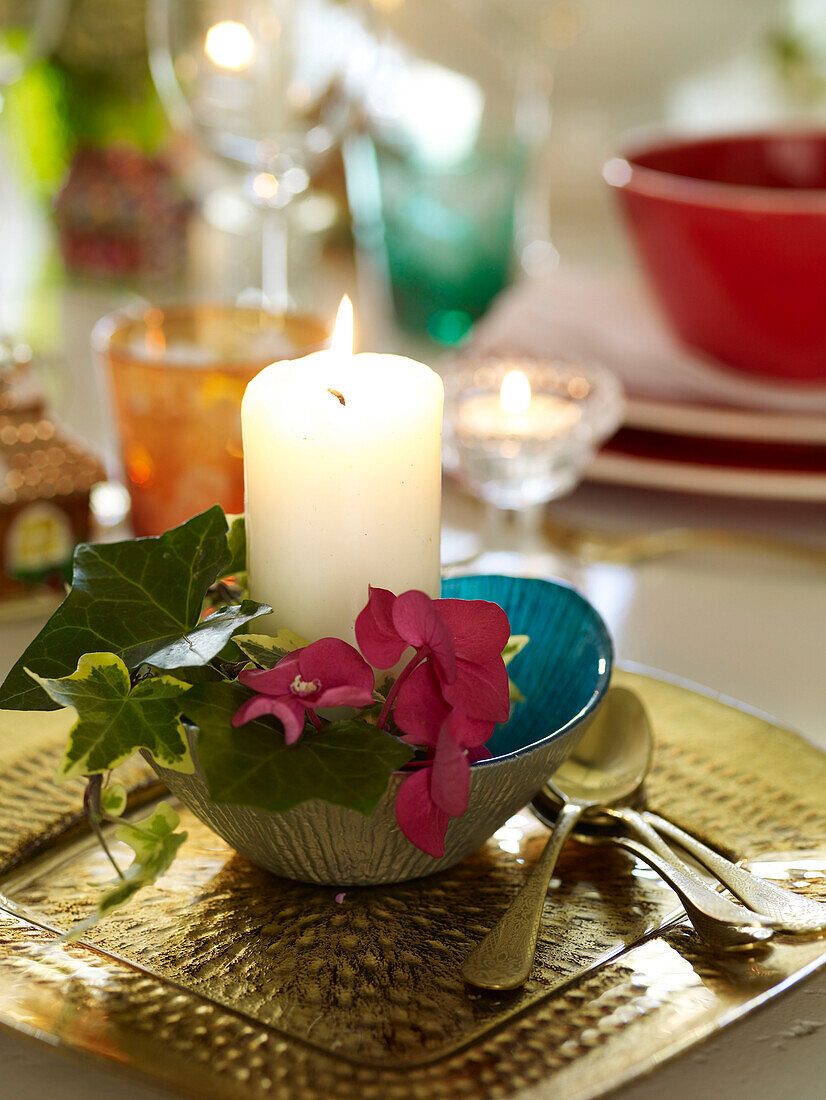 Lit candle with ivy and gold spoons