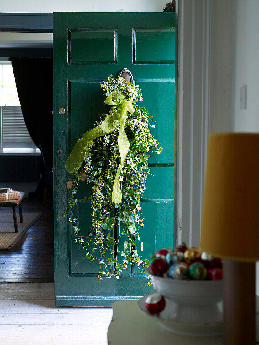 Garlands of ivy tied with ribbon to open front door