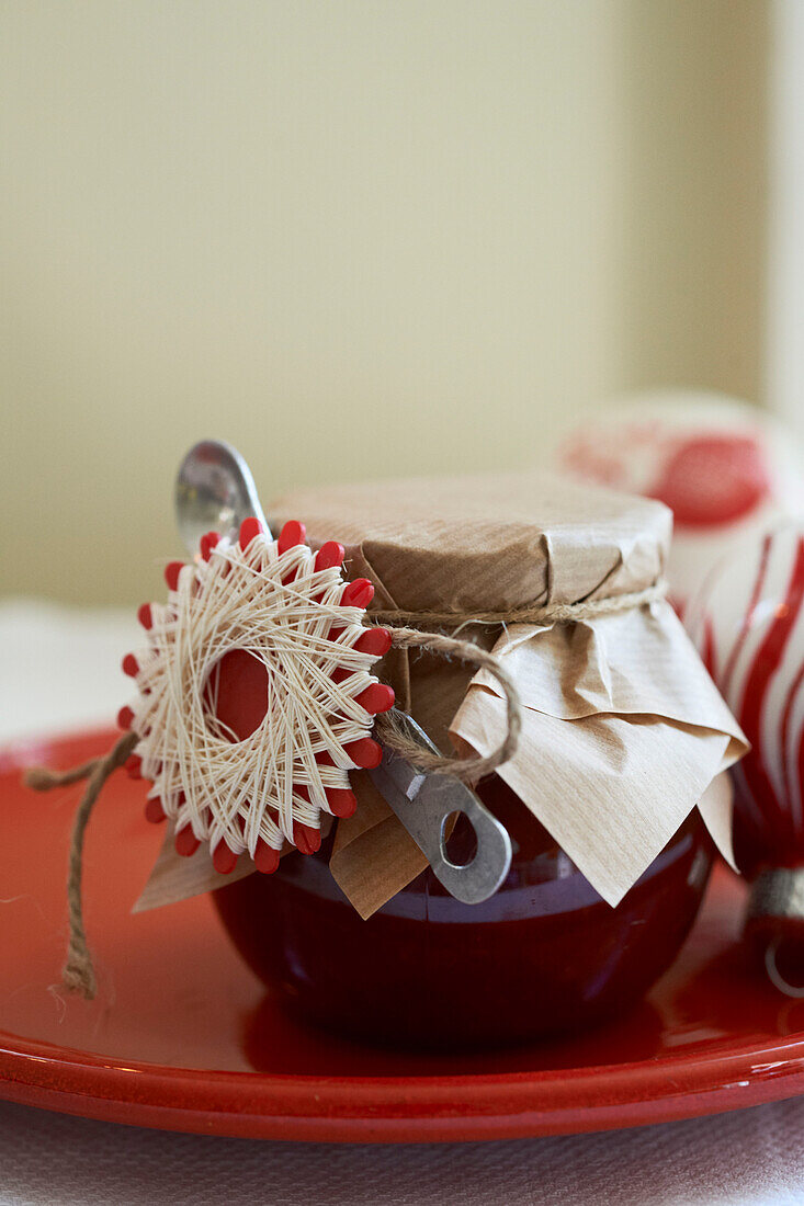 Jam and spoon with brown paper tied with string