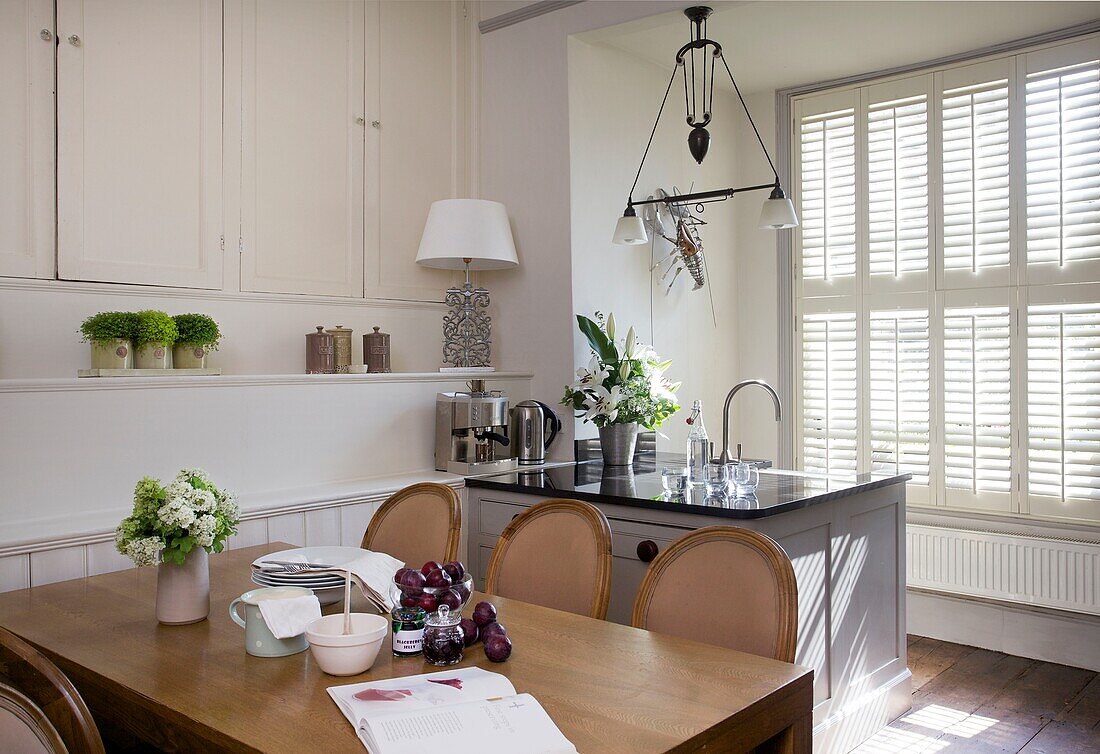 Sunlit kitchen and dining area with plum jam recipe on table in Cranbrook home, Kent, England, UK