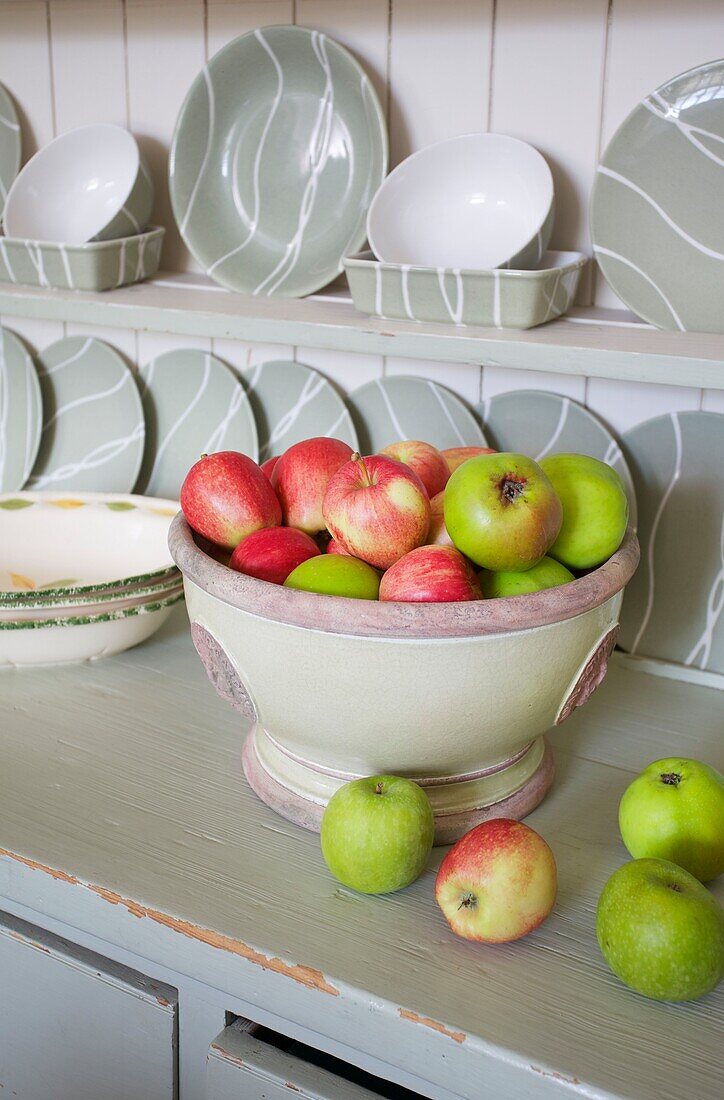 Obstschale mit Äpfeln und Tellern auf der Küchenkommode in einem Haus in Cranbrook, Kent, England, UK