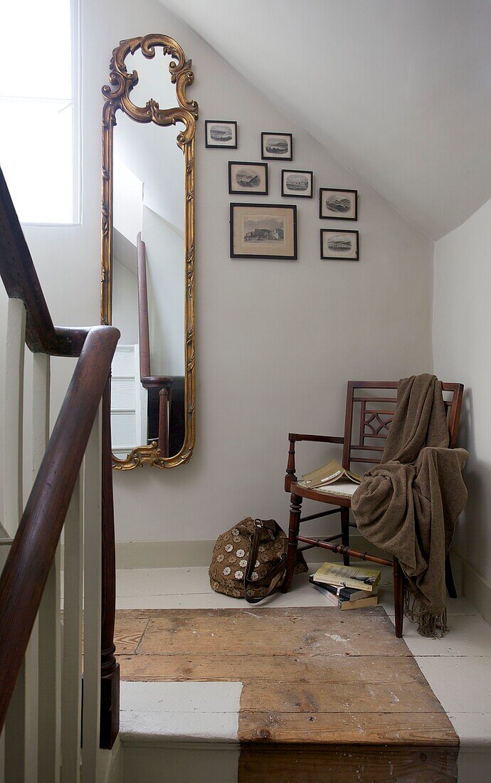 Antiker vergoldeter Spiegel und Stuhl auf einem Treppenabsatz in einem Haus in Cranbrook, Kent, England, UK