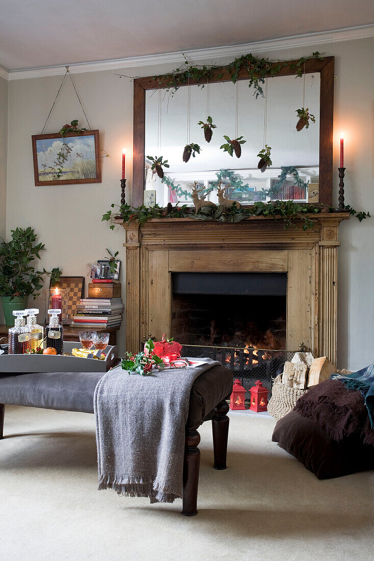 Christmas decorations on mirror with wooden fireplace in living room of Tenterden home, Kent, England, UK