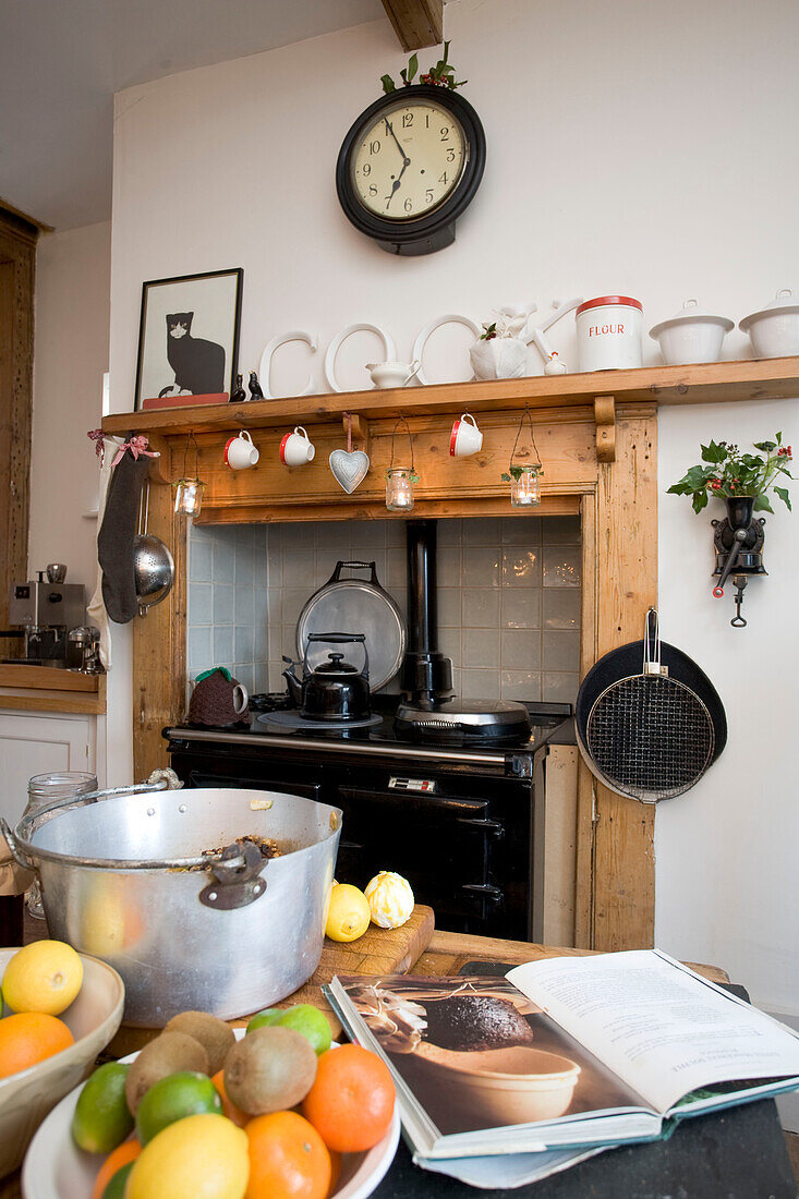 Rezeptbuch und Obst auf der Arbeitsplatte einer Küche in Tenterden mit eingebautem Herd, Kent, England, UK