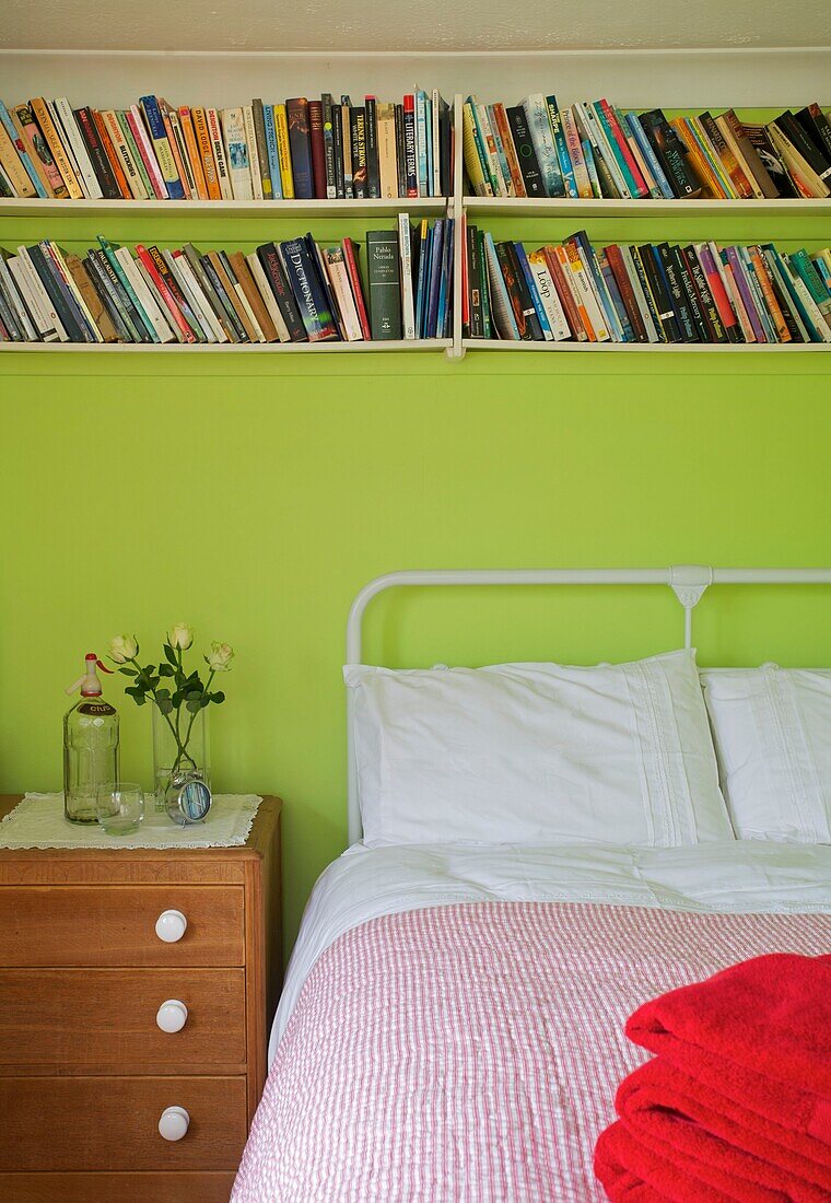 Bücherregal und lindgrüne Wände im Schlafzimmer des Hauses der Familie Cranbrook, Kent, England, UK