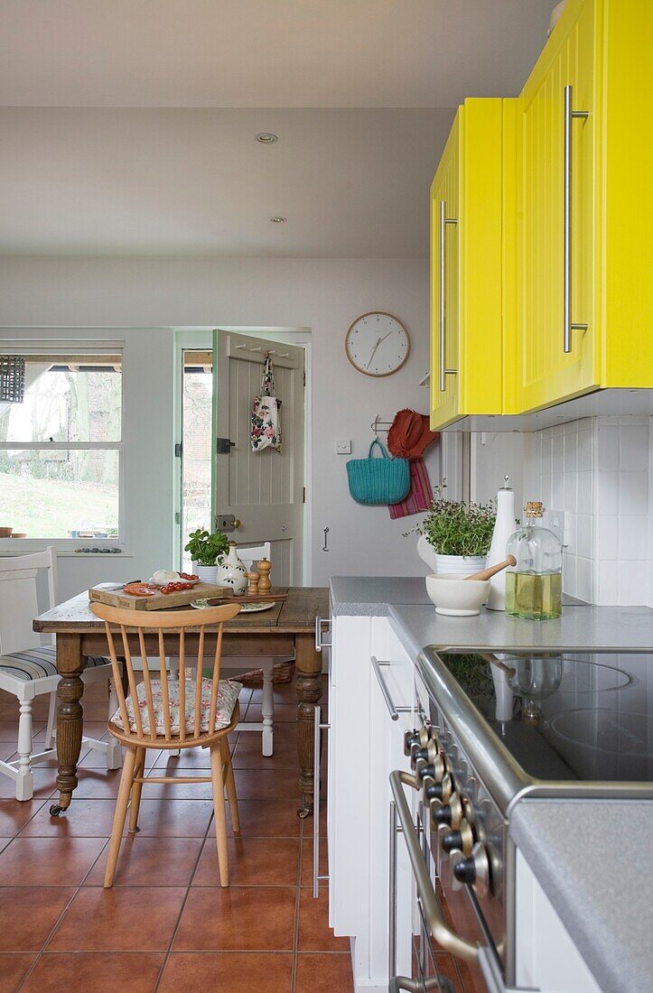 Offene Hintertür in der Küche mit gelben Hängeschränken, Einfamilienhaus in Tenterden, Kent, England, UK
