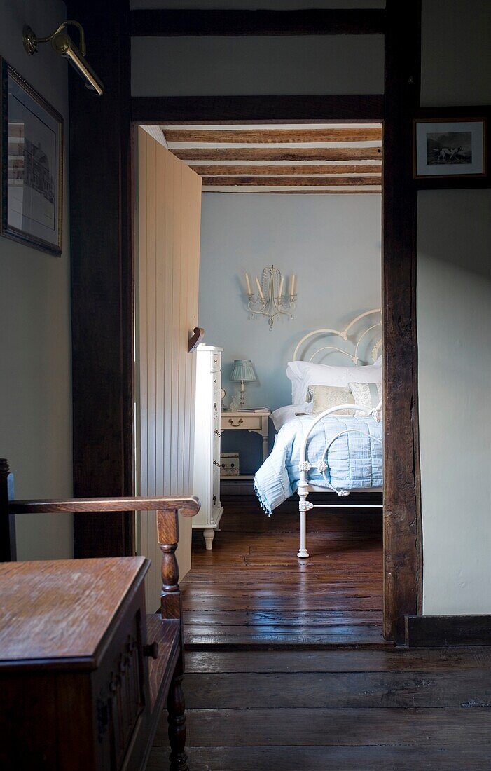 Antike Holzmöbel mit Blick durch die Tür zum Schlafzimmer in einem Fachwerkhaus, Grafty Green, Kent, England, UK