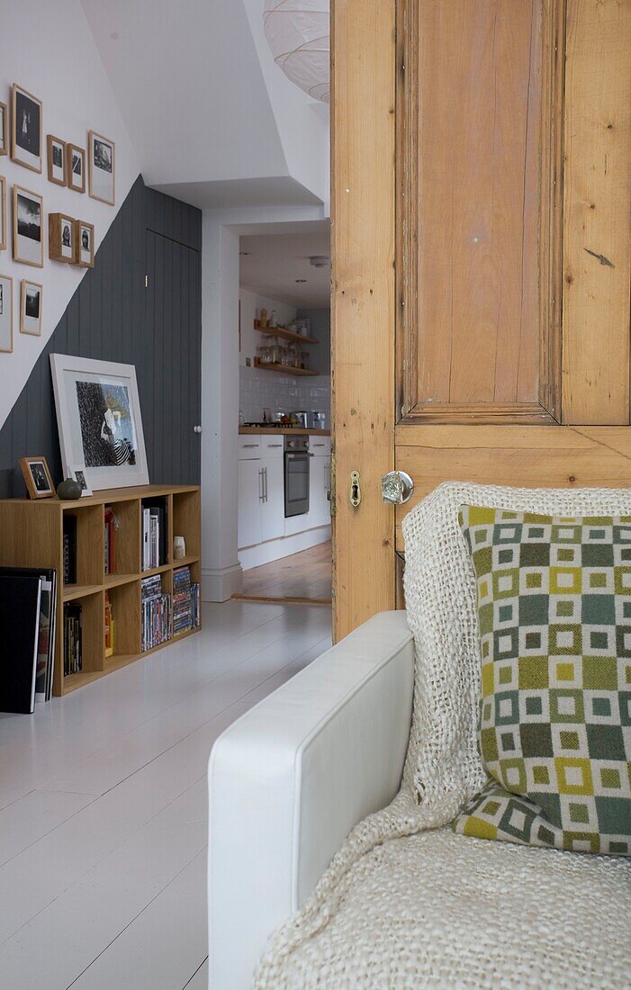 Geometric patterned cushion with view through doorway to shelving unit in St Leonards beach house, East Sussex, England, UK