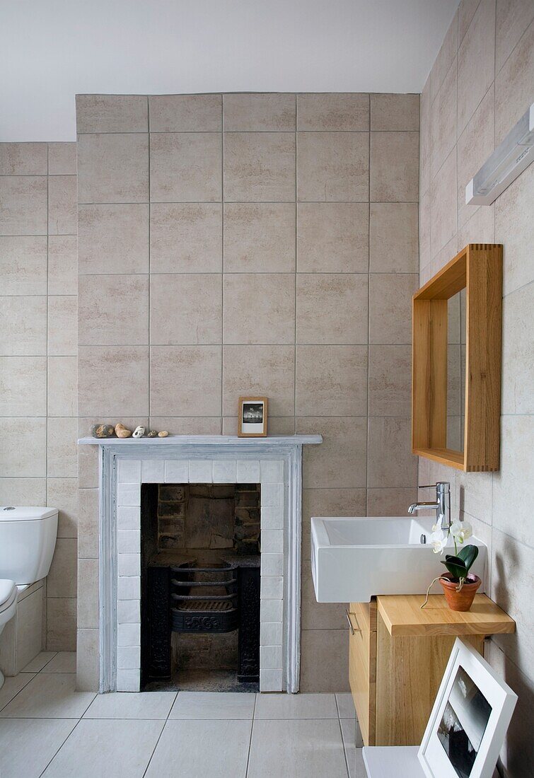 Waschbecken und Spiegel mit originalem Kamin in Strandhaus, St Leonards on Sea, East Sussex, England, UK