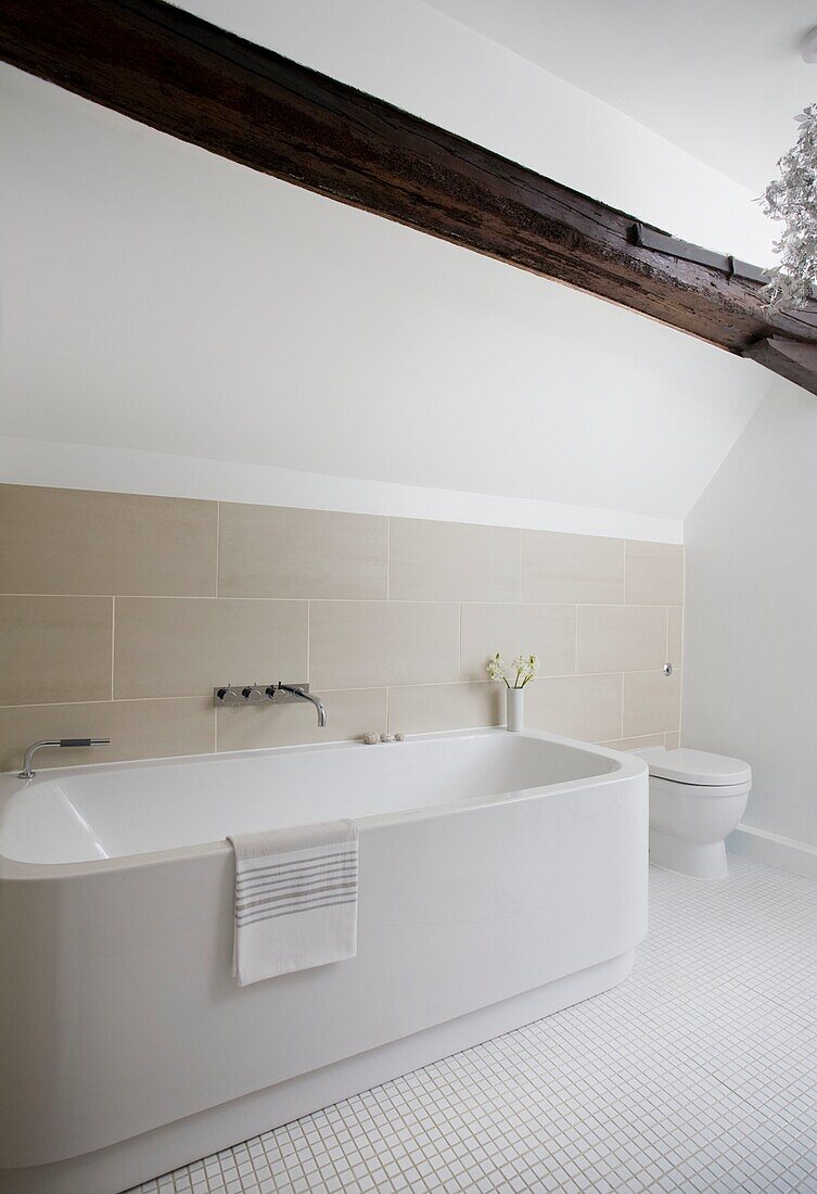 Freestanding bath in neutral timber framed cottage