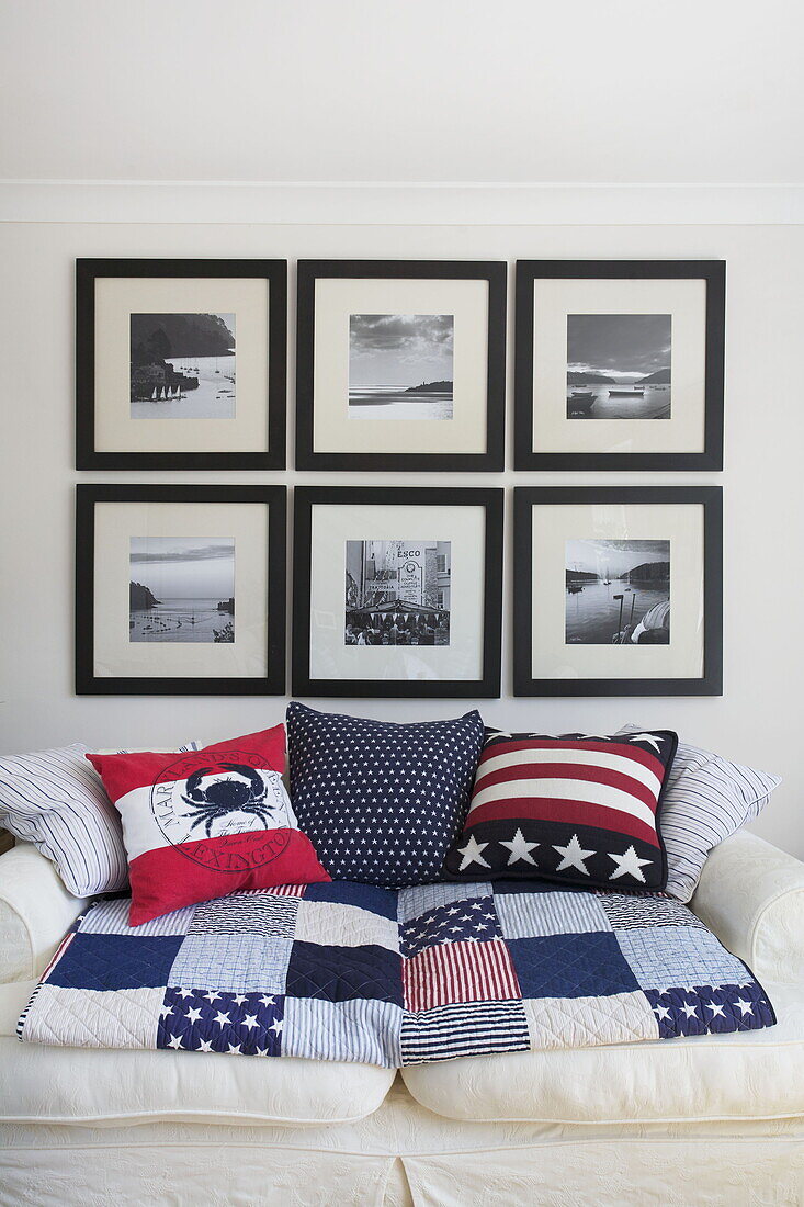Schwarz-Weiß-Fotografien über einem Sofa mit Möbeln im amerikanischen Stil in einem Haus in Dartmouth, Devon, Vereinigtes Königreich