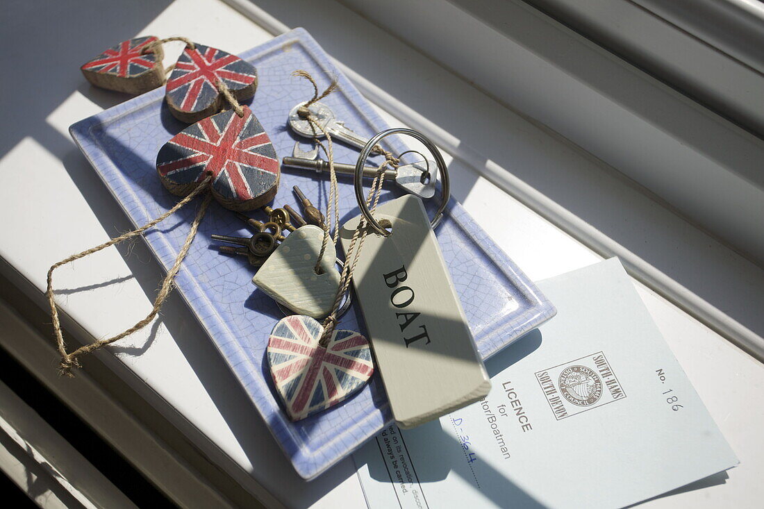 Herzförmige Union Jack-Schlüsselanhänger und Bootsführerschein im Sonnenlicht, Haus in Dartmouth, Devon, Vereinigtes Königreich