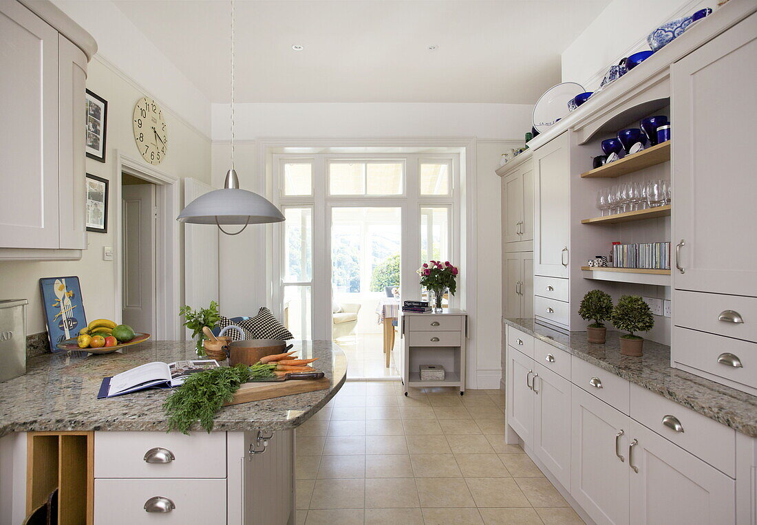 Carrots on chopping board in cream fitted kitchen of Dartmouth home, Devon, UK