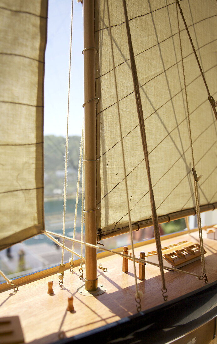 Sonnenbeschienenes Modellboot im Fenster eines Hauses in Dartmouth, Devon, Vereinigtes Königreich