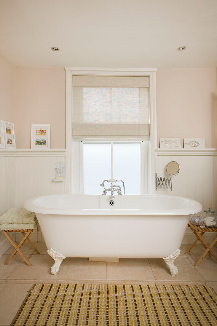 Freistehende weiße Badewanne mit Rolltop am Fenster in einem Haus in Deal, Kent, England UK