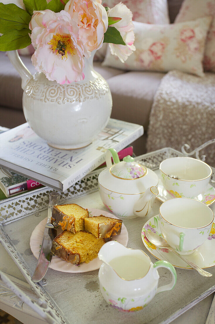 Blumenvase und Biskuitkuchen mit Teeservice im Wohnzimmer des High Halden Bauernhauses Kent England UK