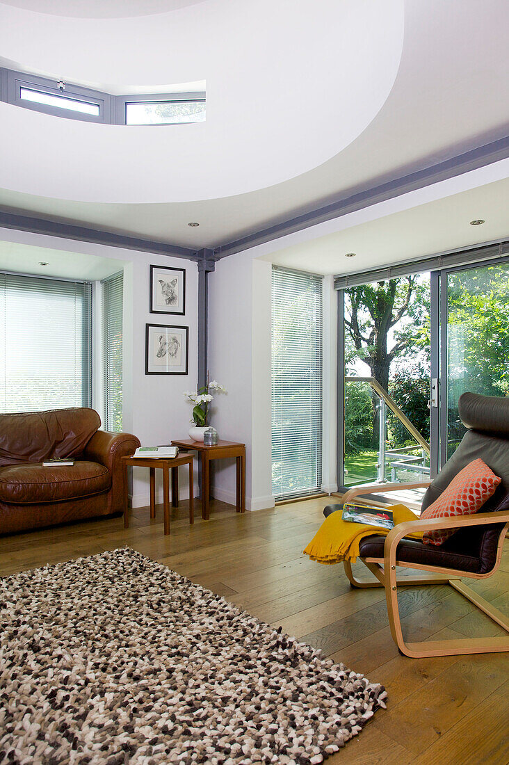 Braunes Ledersofa und Sessel mit Teppich im Wohnzimmer von Rolvenden Wasserturm Umbau Cranbrook Kent England UK