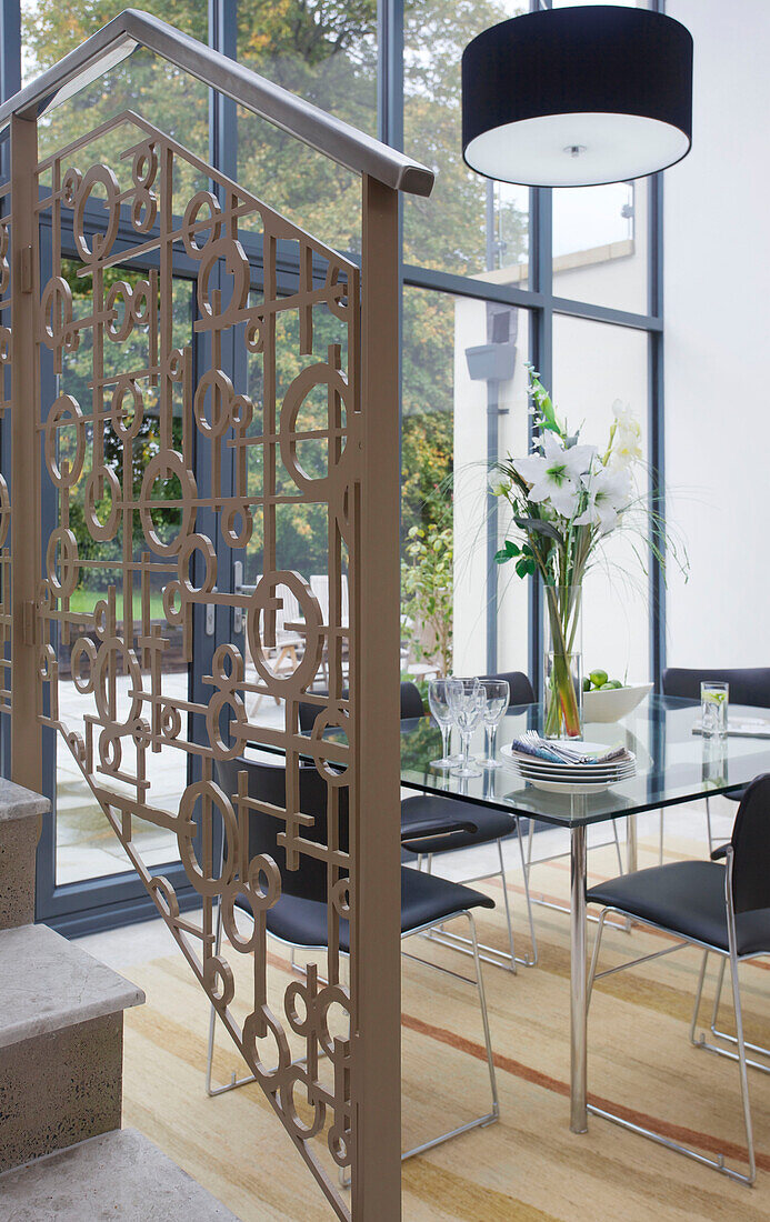 Metallgeländer im Esszimmer mit Glastisch in modernem Haus Bath Somerset, England, UK
