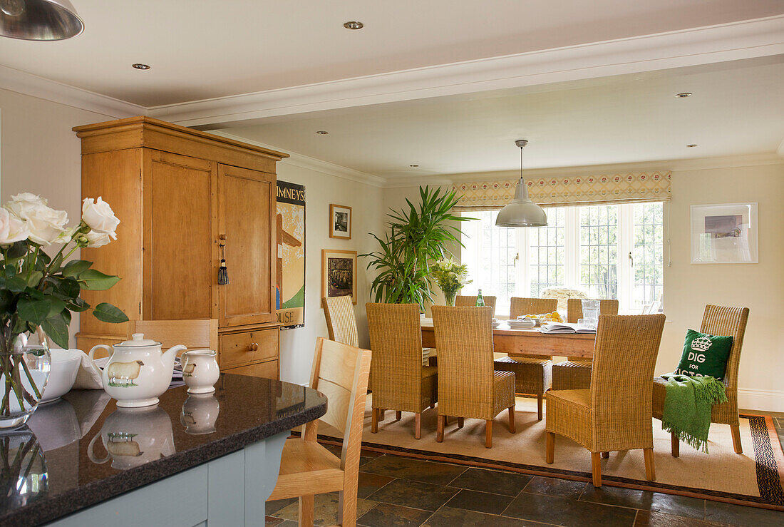 Open plan dining room kitchen with wicker chairs in Smarden home Kent England UK