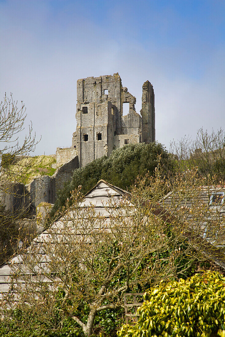 Castle ruins and rooftops in Corfe Castle Dorset England UK