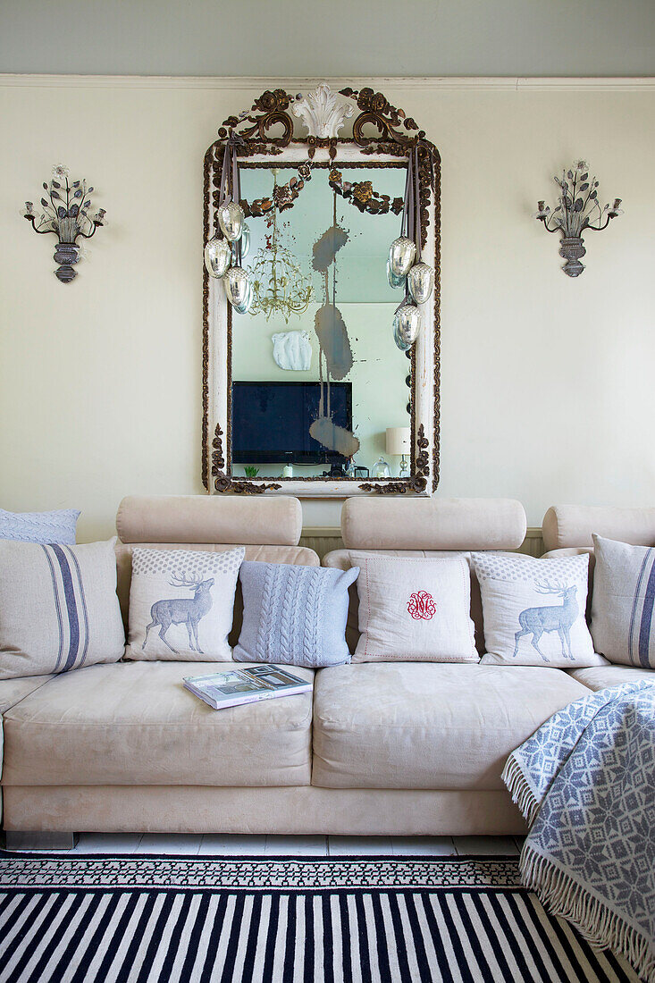 Vintage-Spiegel über cremefarbenem Sofa im Wohnzimmer einer viktorianischen Villa Kent England UK