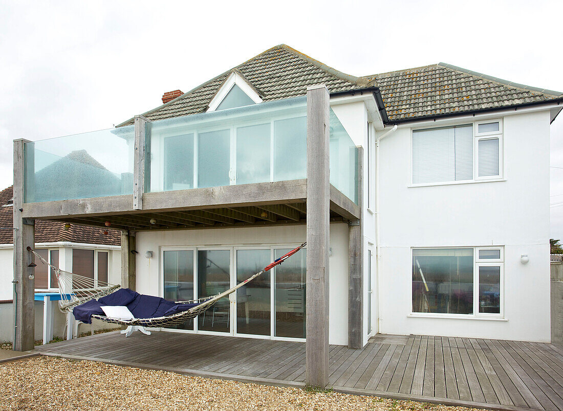 Glasbalkon mit Terrasse an der Außenseite eines freistehenden Strandhauses auf Hayling Island, Hampshire, Großbritannien
