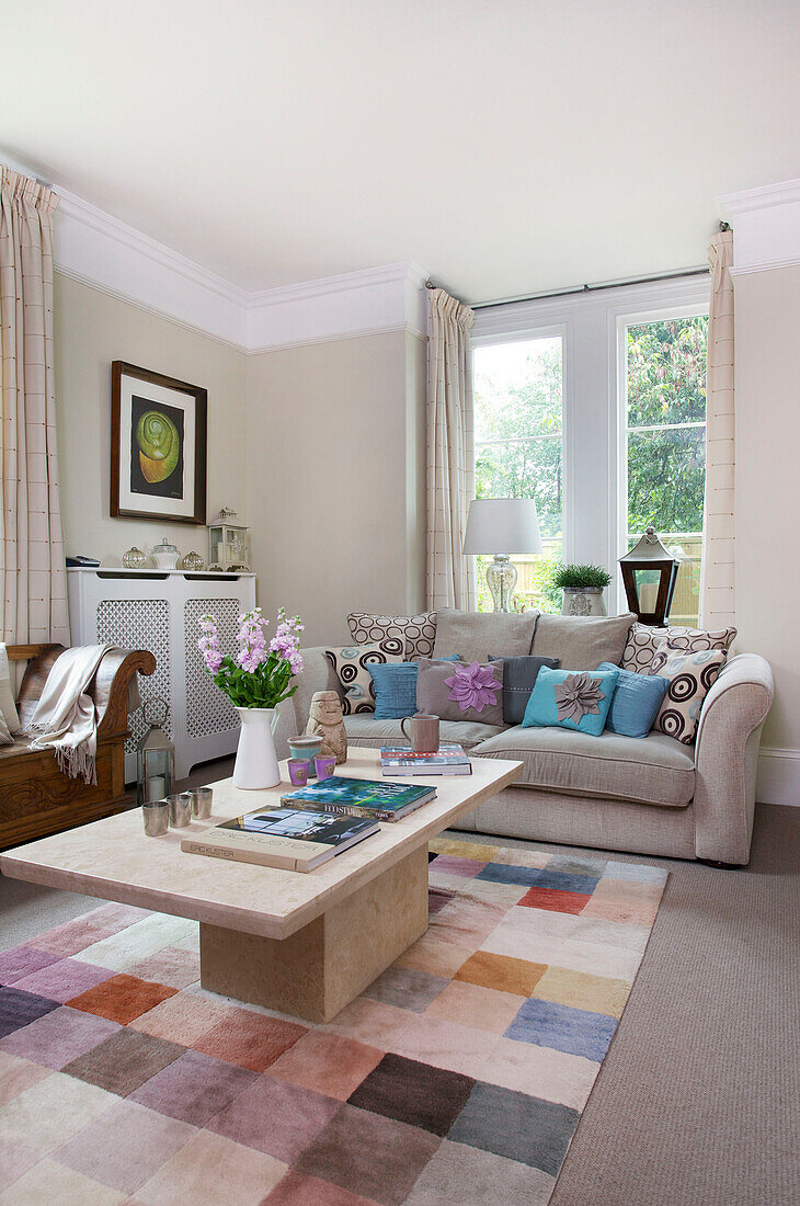 Zweisitzer-Sofa und Couchtisch aus hellem Holz mit kariertem Teppich im Wohnzimmer von Staplehurst, Kent, England, UK