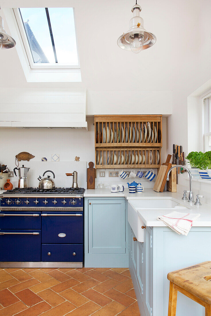 Tellergestell mit blauem Herd in einer Küche in Emsworth mit Oberlicht in Hampshire England UK