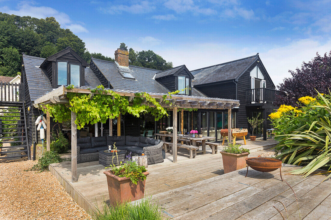 Pergola und Gartenmöbel auf der Terrasse eines Holzhauses in Rye East Sussex UK