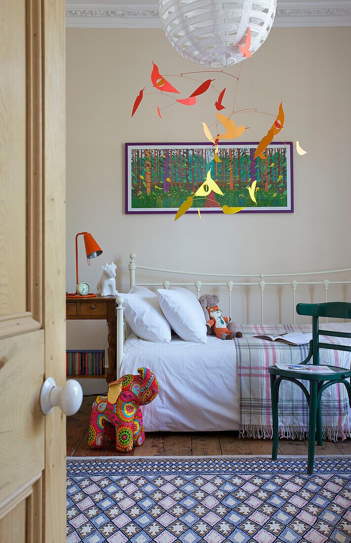 Patterned rug and chair with elephant toy and daybed in Hackney home London England UK