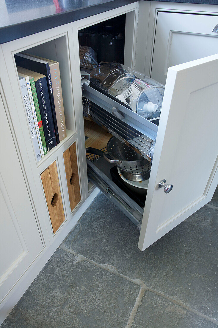 Rezeptbücher und Schiebeschublade in einer Einbauküche in Woodchurch, Kent, England, UK