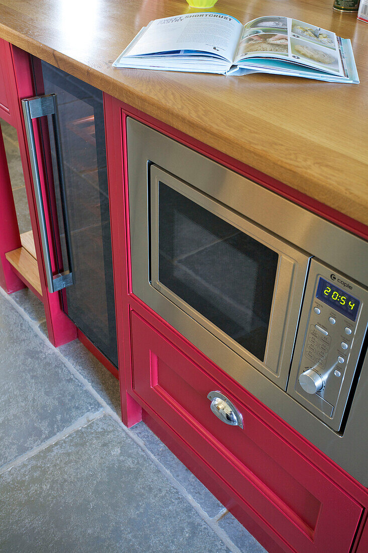 Stainless steel oven in pink island unit in Woodchurch home Kent England UK